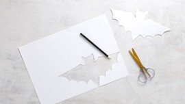 Weißes Blatt Papier mit einer ausgeschnittenen Fledermaus.